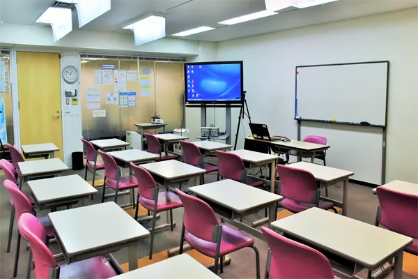 Empty classroom with desks, purple chairs and TV