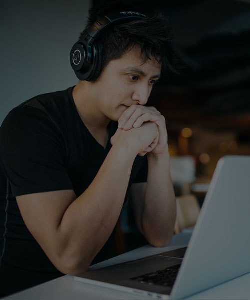 Student in front of computer with headphones